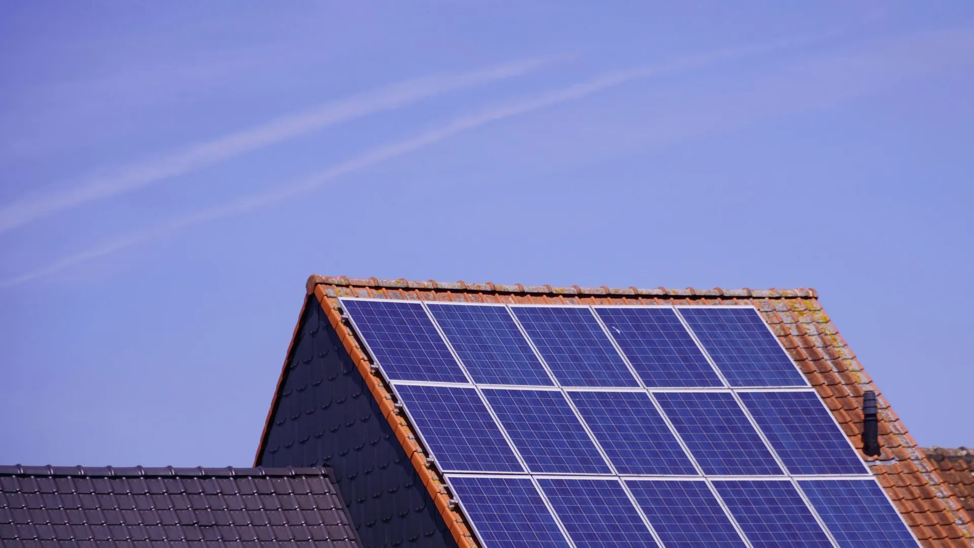 Auf dem Dach eines Hauses sind Solarpaneele installiert.
